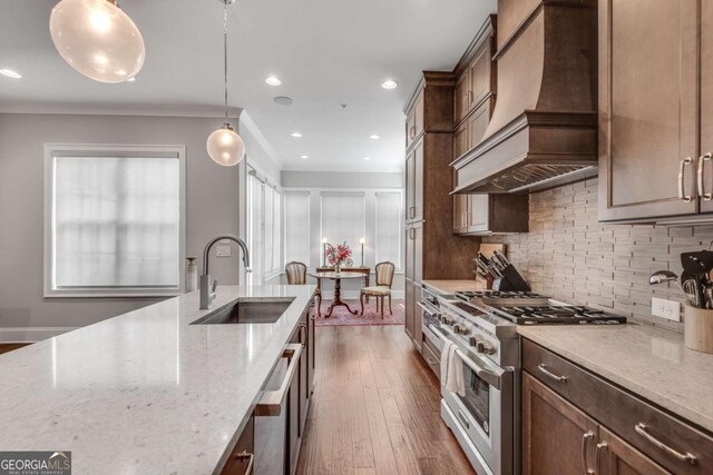 345 Glen Iris Dr NE Unit 3, Atlanta, GA 30312 - kitchen with appliances with stainless steel finishes, premium range hood, tasteful backsplash, light stone counters, and pendant lighting