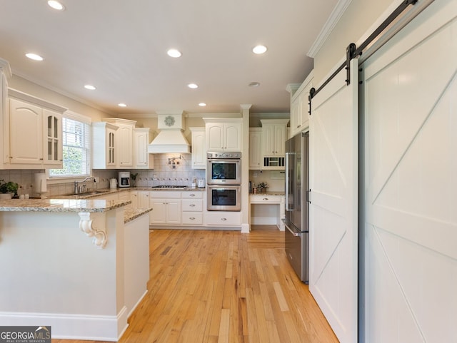 70 Baker Pond Ct, Jefferson, GA 30549 - kitchen with appliances with stainless steel finishes, crown molding, custom exhaust hood, a peninsula, and a kitchen breakfast bar