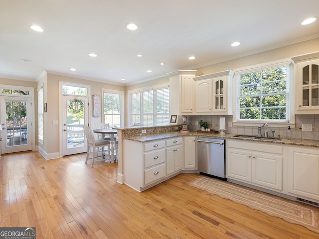 70 Baker Pond Ct, Jefferson, GA 30549 - kitchen with stainless steel dishwasher, a sink, a peninsula, ornamental molding, and light wood finished floors