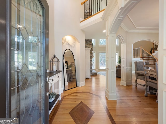 70 Baker Pond Ct, Jefferson, GA 30549 - foyer with a high ceiling, arched walkways, decorative columns, light wood-style floors, and crown molding