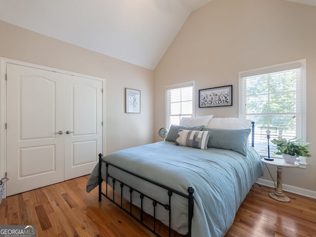 70 Baker Pond Ct, Jefferson, GA 30549 - bedroom with light wood-type flooring, a closet, high vaulted ceiling, and baseboards