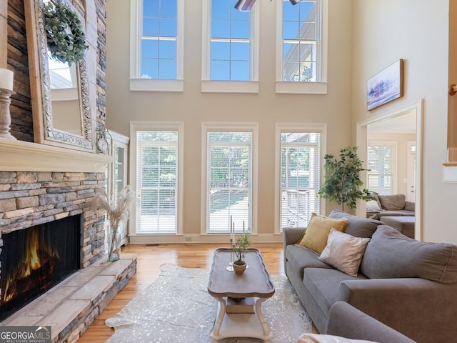 70 Baker Pond Ct, Jefferson, GA 30549 - living room featuring a stone fireplace, wood finished floors, a towering ceiling, and ceiling fan