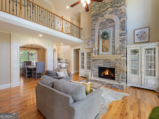 70 Baker Pond Ct, Jefferson, GA 30549 - living area featuring ceiling fan, arched walkways, wood-type flooring, a stone fireplace, and baseboards