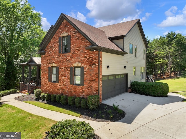 70 Baker Pond Ct, Jefferson, GA 30549 - view of property exterior featuring an attached garage, brick siding, concrete driveway, a lawn, and a shingled roof