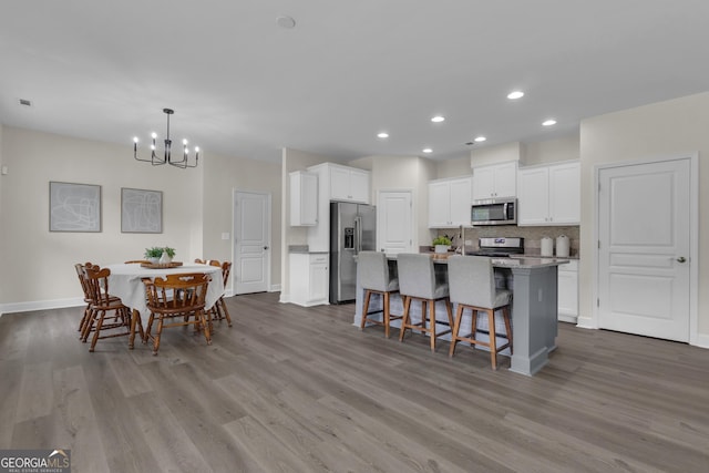206 Roundwood Way, Peachtree City, GA 30269 - kitchen with stainless steel appliances, a chandelier, wood finished floors, white cabinetry, and recessed lighting