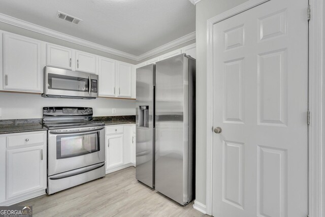 17 Sandy Point Way, Port Wentworth, GA 31407 - kitchen with stainless steel appliances, white cabinets, ornamental molding, light wood-style flooring, and dark stone countertops