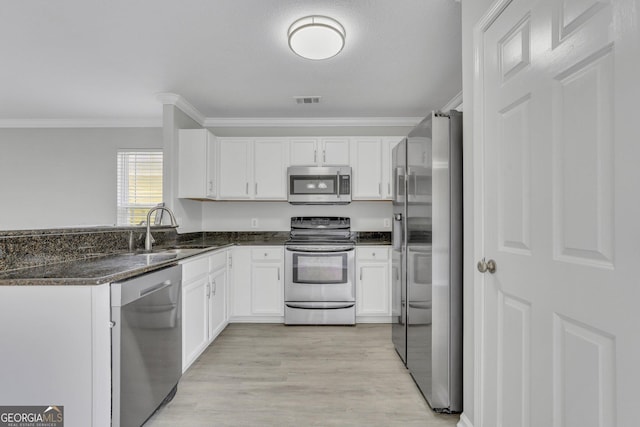17 Sandy Point Way, Port Wentworth, GA 31407 - kitchen with stainless steel appliances, a sink, crown molding, white cabinetry, and light wood-style flooring