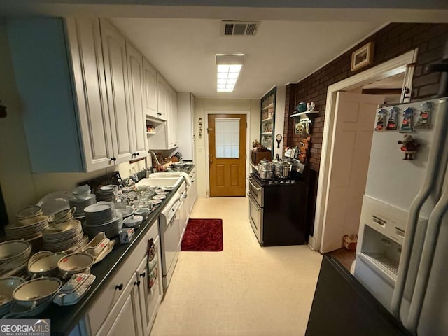 1268 Woodland Rd NE, Conyers, GA 30012 - kitchen featuring white appliances, brick wall, light flooring, dark countertops, and white cabinets