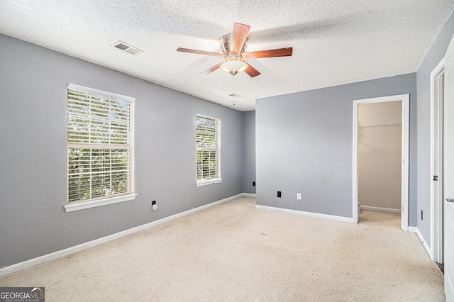 3262 Cascade Parc Blvd SW, Atlanta, GA 30311 - unfurnished bedroom featuring a textured ceiling, carpet flooring, a walk in closet, ceiling fan, and a closet