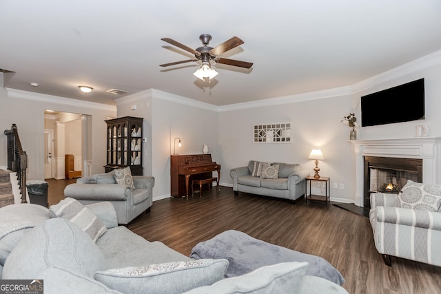 1243 Glenville Ct, Hoschton, GA 30548 - living room with a ceiling fan, wood finished floors, crown molding, a warm lit fireplace, and baseboards