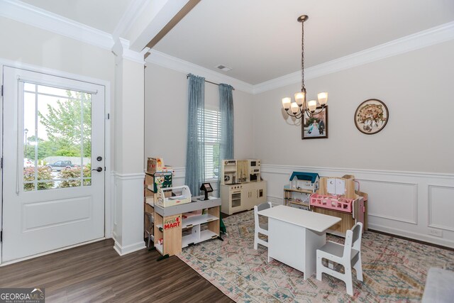 1243 Glenville Ct, Hoschton, GA 30548 - dining room featuring a chandelier, healthy amount of natural light, ornamental molding, a wainscoted wall, and wood finished floors