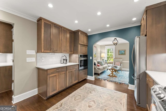 1540 Kinglet Ln, Marietta, GA 30062 - kitchen with appliances with stainless steel finishes, arched walkways, ornamental molding, light countertops, and baseboards