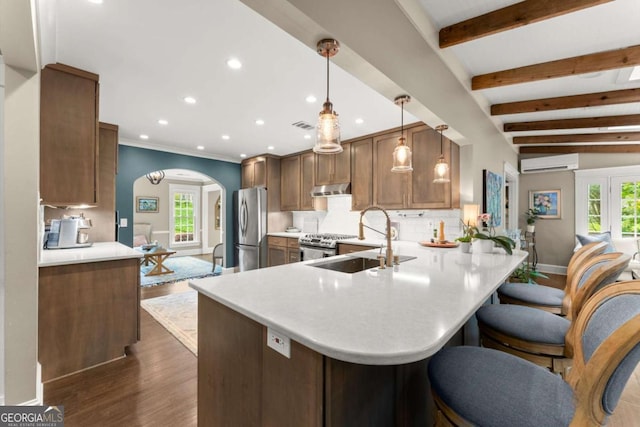 1540 Kinglet Ln, Marietta, GA 30062 - kitchen featuring stainless steel appliances, a wall mounted air conditioner, a sink, arched walkways, and under cabinet range hood