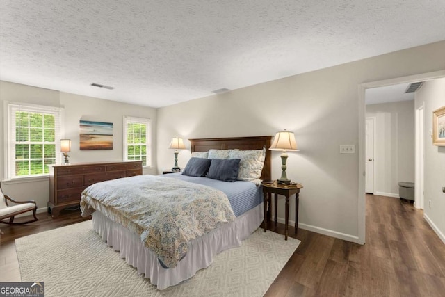 1540 Kinglet Ln, Marietta, GA 30062 - bedroom featuring wood finished floors, multiple windows, baseboards, and a textured ceiling