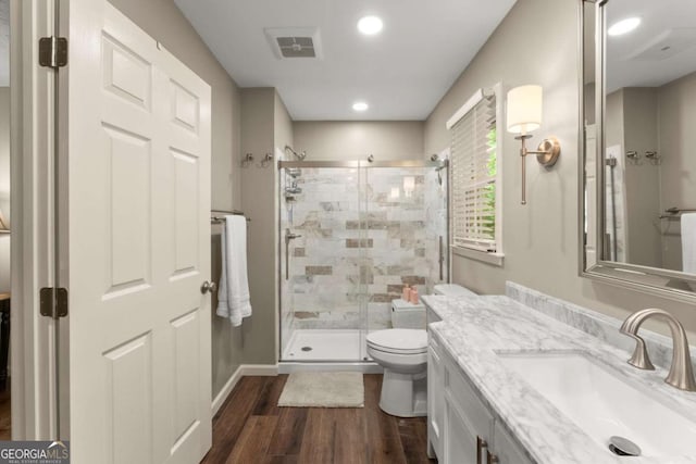 1540 Kinglet Ln, Marietta, GA 30062 - bathroom with wood finished floors, a shower stall, vanity, toilet, and recessed lighting