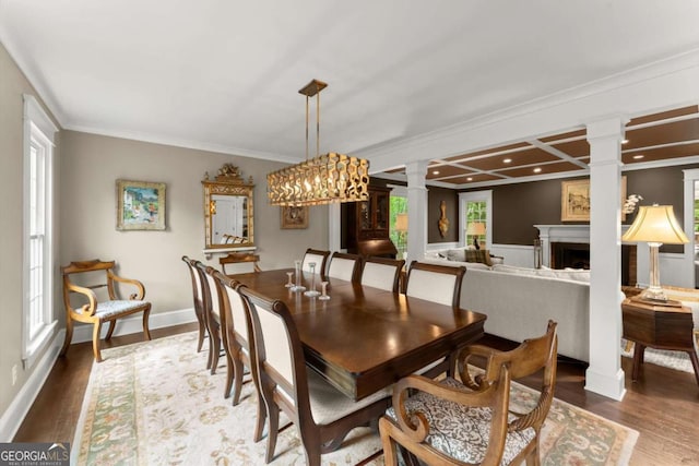 1540 Kinglet Ln, Marietta, GA 30062 - dining space featuring ornate columns, crown molding, wood finished floors, a fireplace, and baseboards