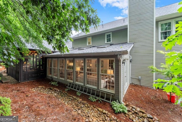 1540 Kinglet Ln, Marietta, GA 30062 - back of property featuring a sunroom, a shingled roof, and a chimney