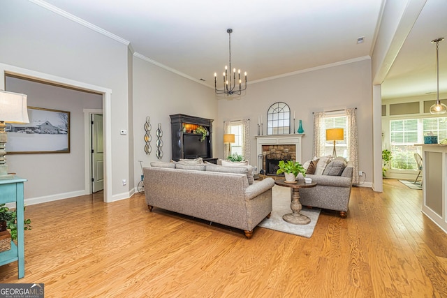 172 Walden Pond Trl, Senoia, GA 30276 - living room featuring a fireplace, light wood-type flooring, baseboards, a chandelier, and ornamental molding