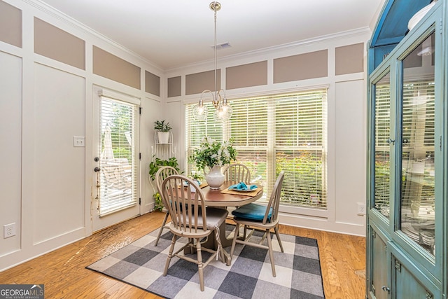 172 Walden Pond Trl, Senoia, GA 30276 - dining room with crown molding, a decorative wall, and light wood-type flooring