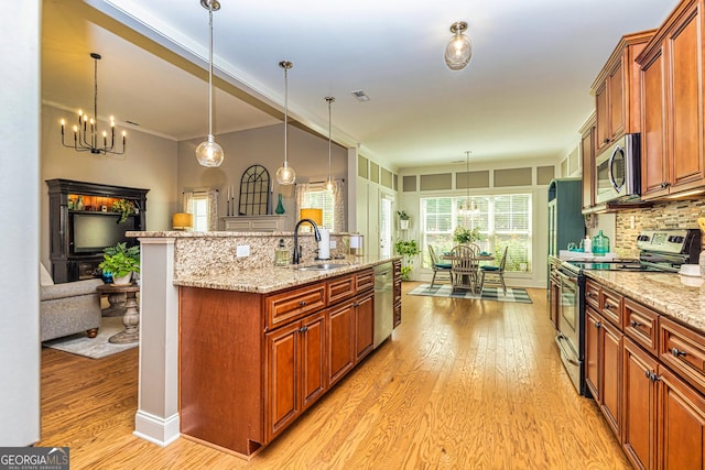 172 Walden Pond Trl, Senoia, GA 30276 - kitchen featuring appliances with stainless steel finishes, a sink, light wood-style flooring, a center island with sink, and crown molding