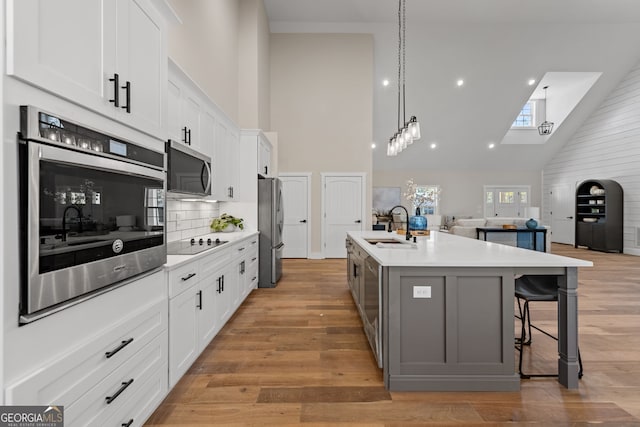 219 Fairview Dr, Morganton, GA 30560 - kitchen with stainless steel appliances, high vaulted ceiling, open floor plan, light countertops, and white cabinetry