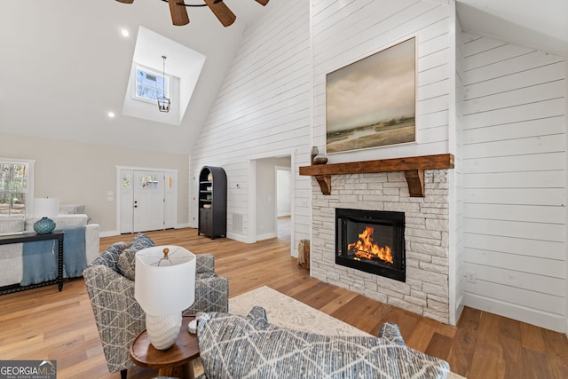 219 Fairview Dr, Morganton, GA 30560 - living room featuring high vaulted ceiling, a fireplace, a skylight, ceiling fan, and wood finished floors