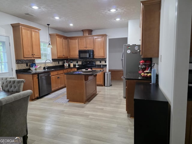 10315 Whisper Glen Dr, Midland, GA 31820 - kitchen with black appliances, a center island, a textured ceiling, dark countertops, and decorative backsplash