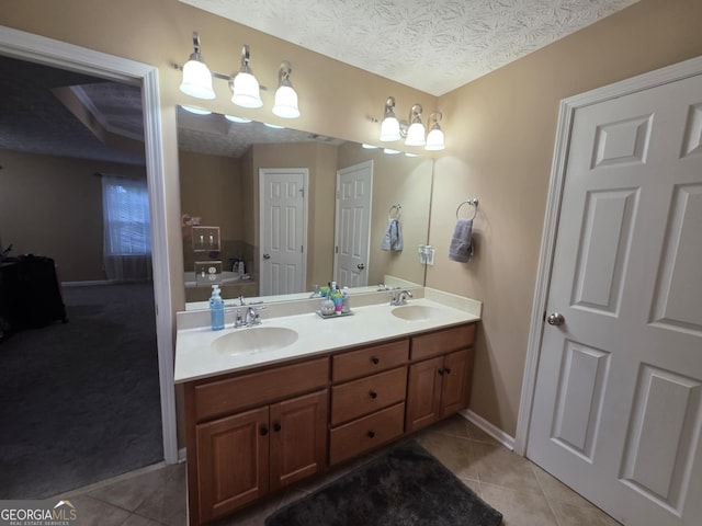 10315 Whisper Glen Dr, Midland, GA 31820 - full bath with double vanity, tile patterned flooring, a tub, baseboards, and a textured ceiling