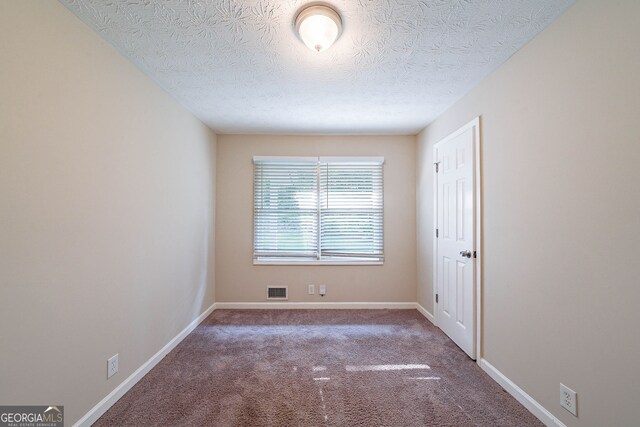 4457 Lincoln Jones Rd, Ellenwood, GA 30294 - carpeted spare room with a textured ceiling and baseboards
