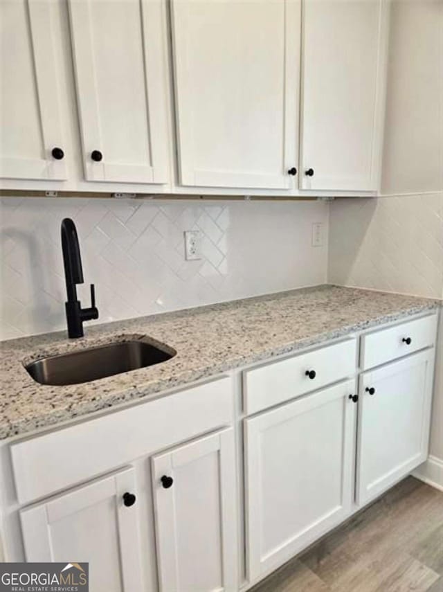 1695 Crumbley Rd Unit 3, Mcdonough, GA 30252 - kitchen with a sink, white cabinetry, light wood finished floors, and backsplash