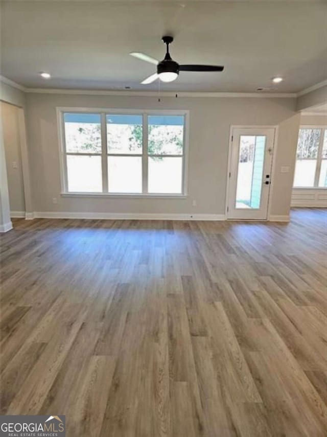 1695 Crumbley Rd Unit 3, Mcdonough, GA 30252 - unfurnished living room with baseboards, ornamental molding, a ceiling fan, wood finished floors, and recessed lighting