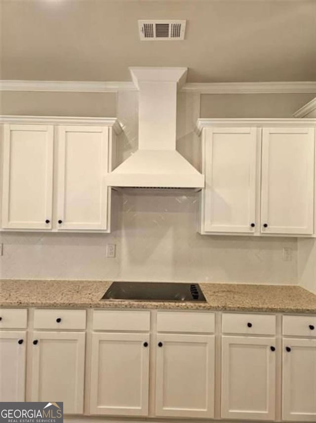 1695 Crumbley Rd Unit 3, Mcdonough, GA 30252 - kitchen featuring premium range hood, white cabinets, black electric stovetop, and ornamental molding