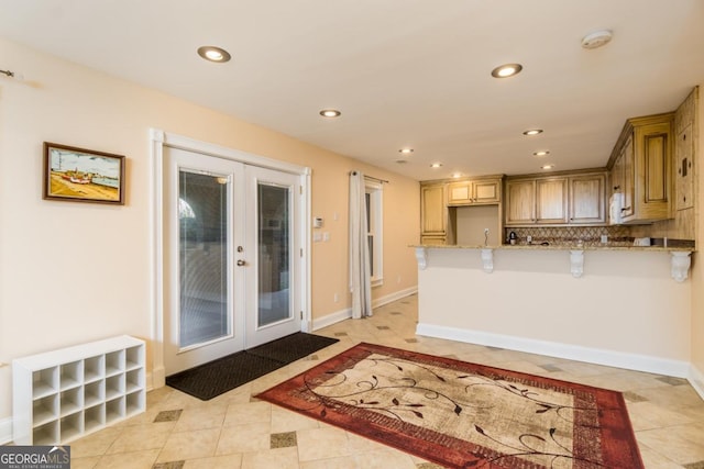 271 Double Gate Ct, Sugar Hill, GA 30518 - kitchen with french doors, light stone counters, a peninsula, recessed lighting, and light tile patterned floors