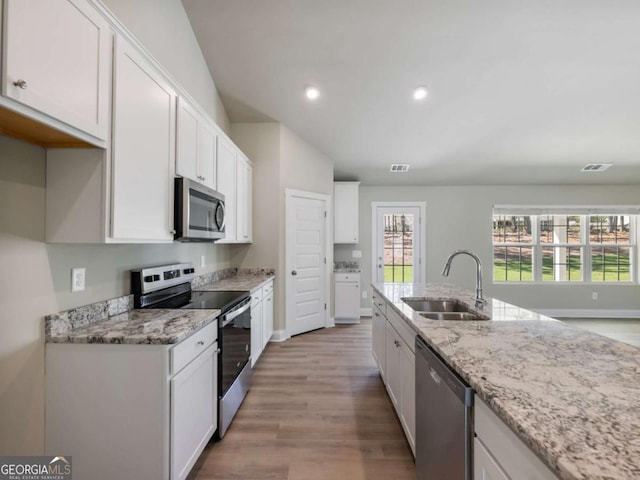 204 Rachel Ln, Hartwell, GA 30643 - kitchen featuring appliances with stainless steel finishes, a sink, wood finished floors, white cabinetry, and light stone countertops