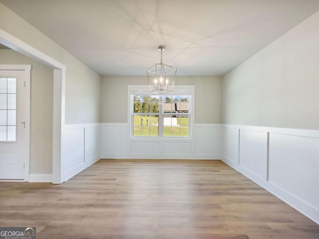 204 Rachel Ln, Hartwell, GA 30643 - unfurnished dining area with a chandelier, healthy amount of natural light, wood finished floors, and a wainscoted wall