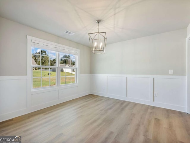 204 Rachel Ln, Hartwell, GA 30643 - unfurnished dining area with a chandelier, wood finished floors, a wainscoted wall, and a decorative wall