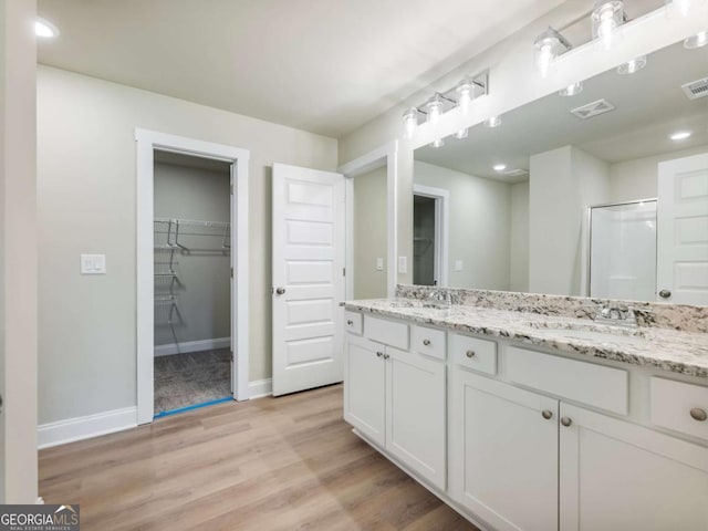 204 Rachel Ln, Hartwell, GA 30643 - full bathroom with double vanity, wood finished floors, a walk in closet, and baseboards