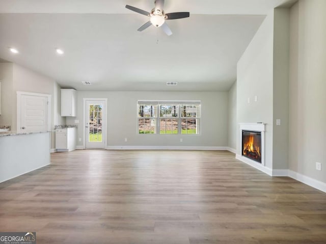 204 Rachel Ln, Hartwell, GA 30643 - unfurnished living room with lofted ceiling, a glass covered fireplace, ceiling fan, recessed lighting, and light wood-style floors