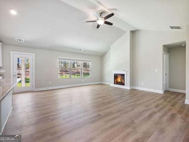 204 Rachel Ln, Hartwell, GA 30643 - unfurnished living room with lofted ceiling, a ceiling fan, a glass covered fireplace, baseboards, and light wood-style flooring