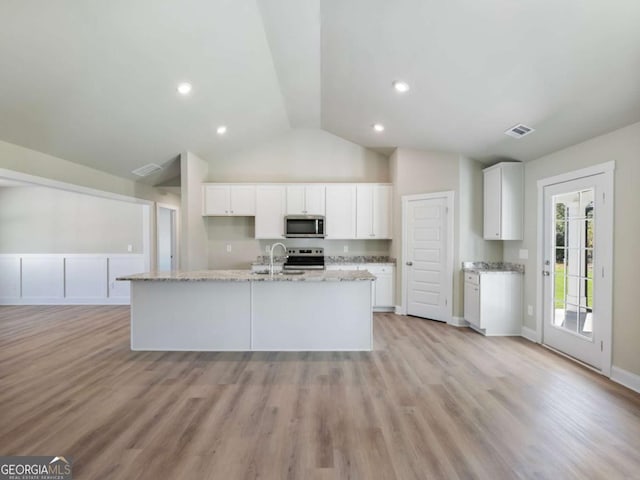 204 Rachel Ln, Hartwell, GA 30643 - kitchen with stainless steel microwave, a sink, vaulted ceiling, light stone countertops, and white cabinetry