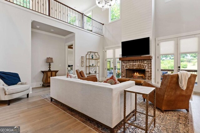 4110 Gentle Breeze Way, Braselton, GA 30517 - living room with a towering ceiling, a fireplace, wood finished floors, plenty of natural light, and crown molding