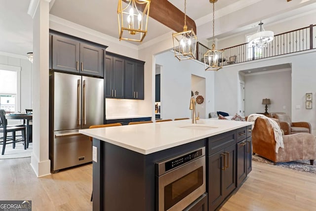 4110 Gentle Breeze Way, Braselton, GA 30517 - kitchen with appliances with stainless steel finishes, a chandelier, light wood finished floors, open floor plan, and a sink