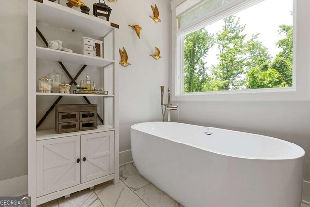 4110 Gentle Breeze Way, Braselton, GA 30517 - bathroom featuring a freestanding tub and marble look tile flooring