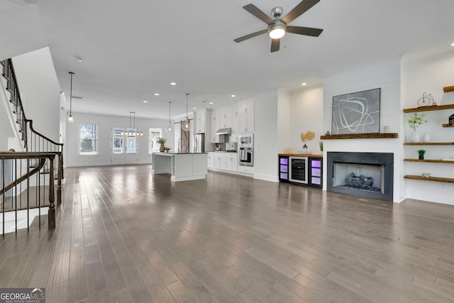 113 Quinn Way, Milton, GA 30004 - unfurnished living room featuring a ceiling fan, recessed lighting, stairway, dark wood-style flooring, and a large fireplace