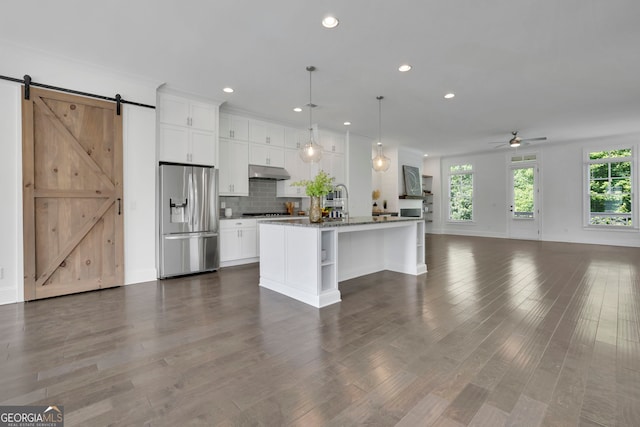113 Quinn Way, Milton, GA 30004 - kitchen with stainless steel fridge, open floor plan, a barn door, a ceiling fan, and white cabinets