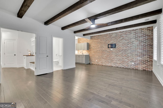 113 Quinn Way, Milton, GA 30004 - unfurnished living room featuring brick wall, a ceiling fan, dark wood finished floors, baseboards, and beamed ceiling