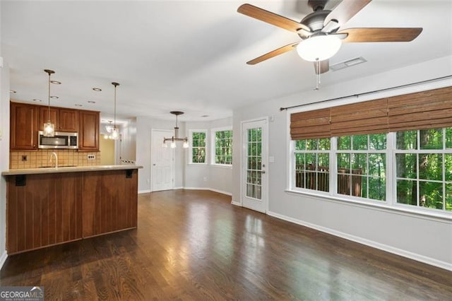 14 Augusta Way, Hiram, GA 30141 - kitchen with stainless steel microwave, baseboards, brown cabinets, a ceiling fan, and decorative backsplash