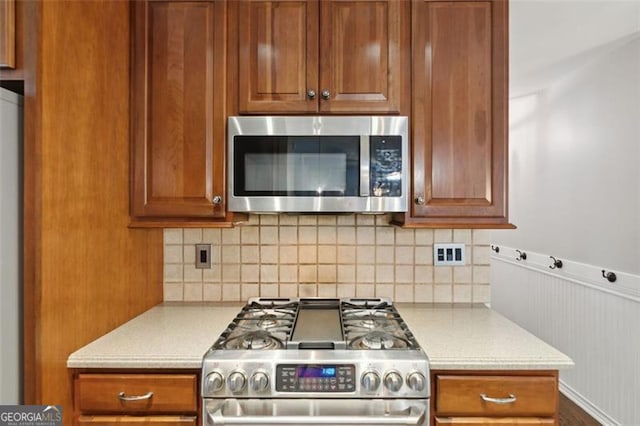 14 Augusta Way, Hiram, GA 30141 - kitchen featuring stainless steel appliances, light countertops, decorative backsplash, and brown cabinets