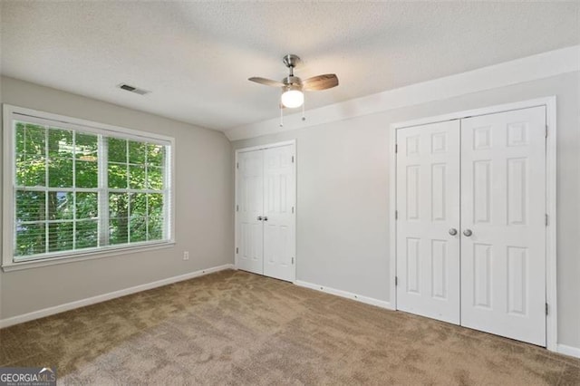 14 Augusta Way, Hiram, GA 30141 - unfurnished bedroom featuring two closets, carpet flooring, a textured ceiling, and a ceiling fan