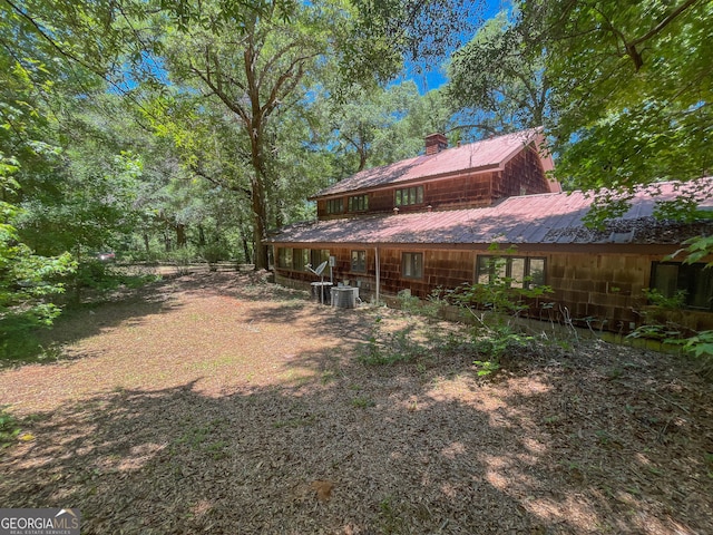 3222 US Highway 80 W, Dublin, GA 31021 - rear view of house with a chimney, central air condition unit, and metal roof